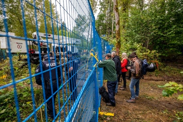 Burnaby RCMP after extracting a tree sitter from a TMX pipeline construction site in Burnaby.  (Ben Nelms/CBC - image credit)