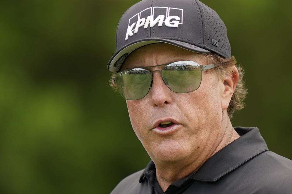 FILE - Phil Mickelson greets spectators as he walks onto the 16th tee in the first round of play at the Northern Trust golf tournament, Thursday, Aug. 19, 2021, at Liberty National Golf Course in Jersey City, N.J. Whether his true intentions were chasing Saudi Arabian money or gaining more control over how he thinks the PGA Tour should be run, Mickelson has been exposed for manipulating people to get what he wants. (AP Photo/John Minchillo, File)