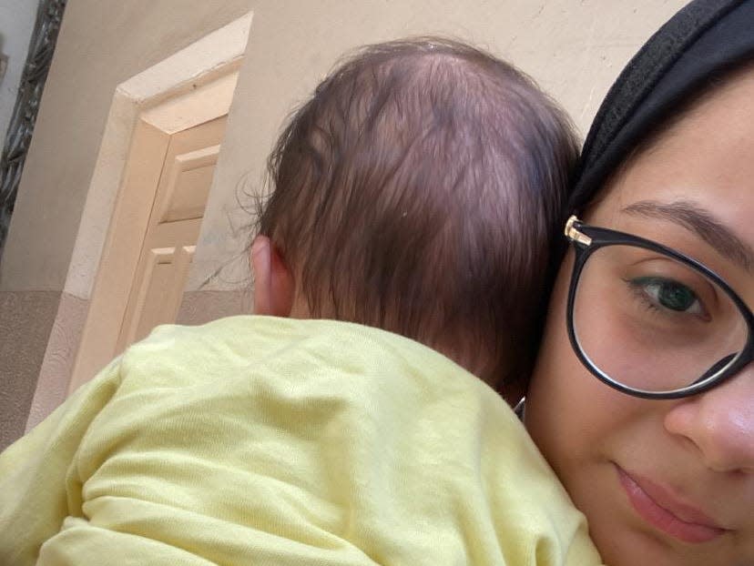 A woman takes a selfie while holding a baby.