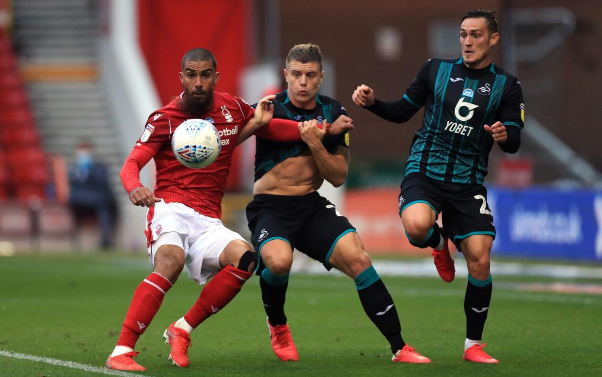 Nottingham Forest's Lewis Grabban (left) and Swansea City's Jake Bidwell (centre) battle for the ball during the Sky Bet Championship match at the City Ground, Nottingham. PA Photo. Issue date: Wednesday July 15, 2020. - PA
