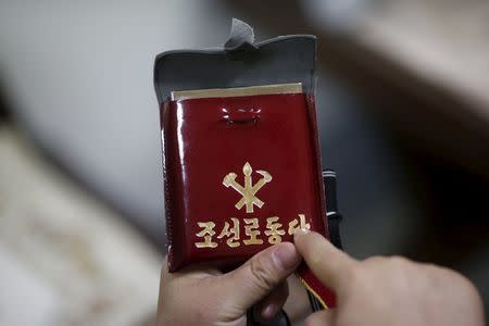 Seo Jae-pyoung, the secretary general of the association of the North Korean defectors, looks at a Workers' Party membership card holder while demonstrating the use of it during an interview with Reuters in Seoul, South Korea, April 22, 2016. REUTERS/Kim Hong-Ji