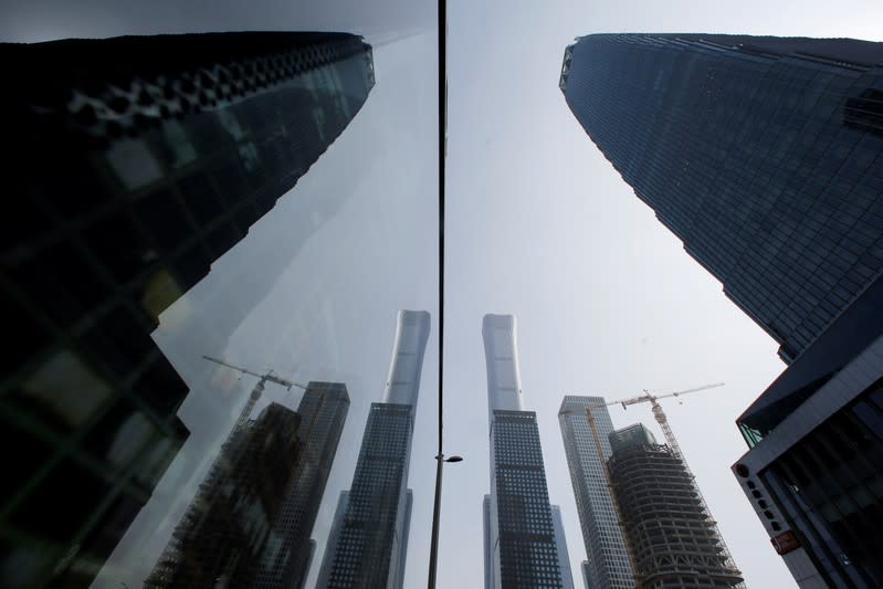 FILE PHOTO: Skyscrapers in the Central Business District (CBD) are reflected in a window in Beijing