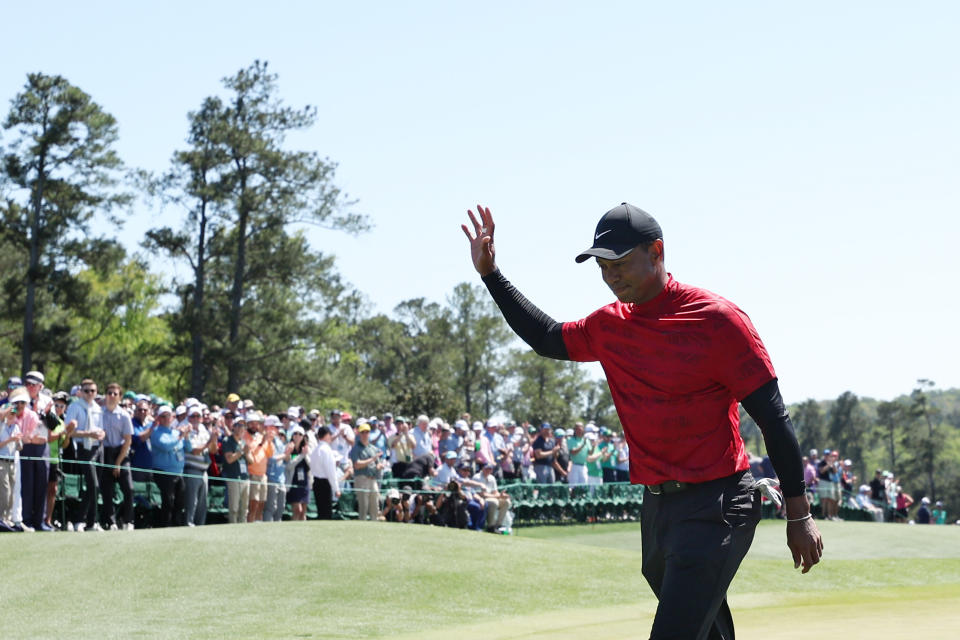 Seen here, Tiger Woods waving to the crowd on the 18th green after closing out his Masters tournament.