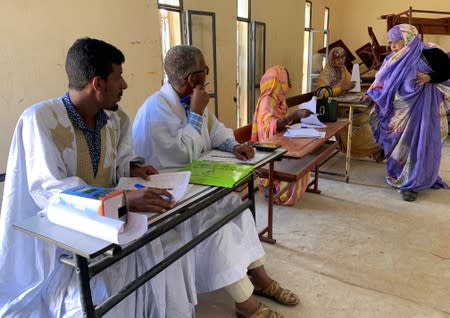 A woman attends voting at a polling station during presidential election in Nouakchott