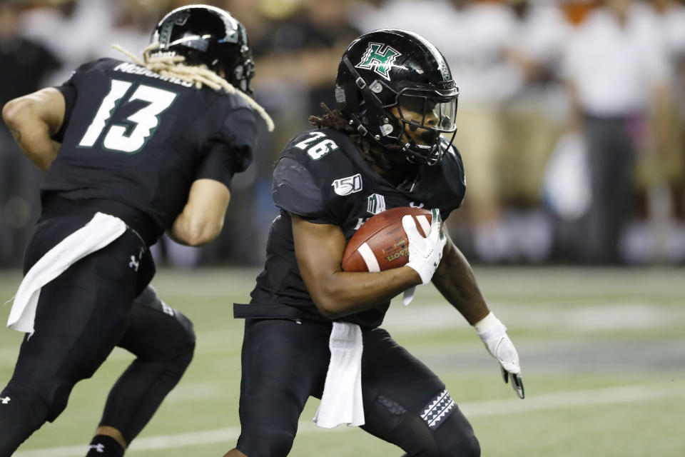 Hawaii running back Miles Reed (26) runs through the Army defense during the second half of an NCAA college football game Saturday, Nov. 30, 2019 in Honolulu. (AP Photo/Marco Garcia)