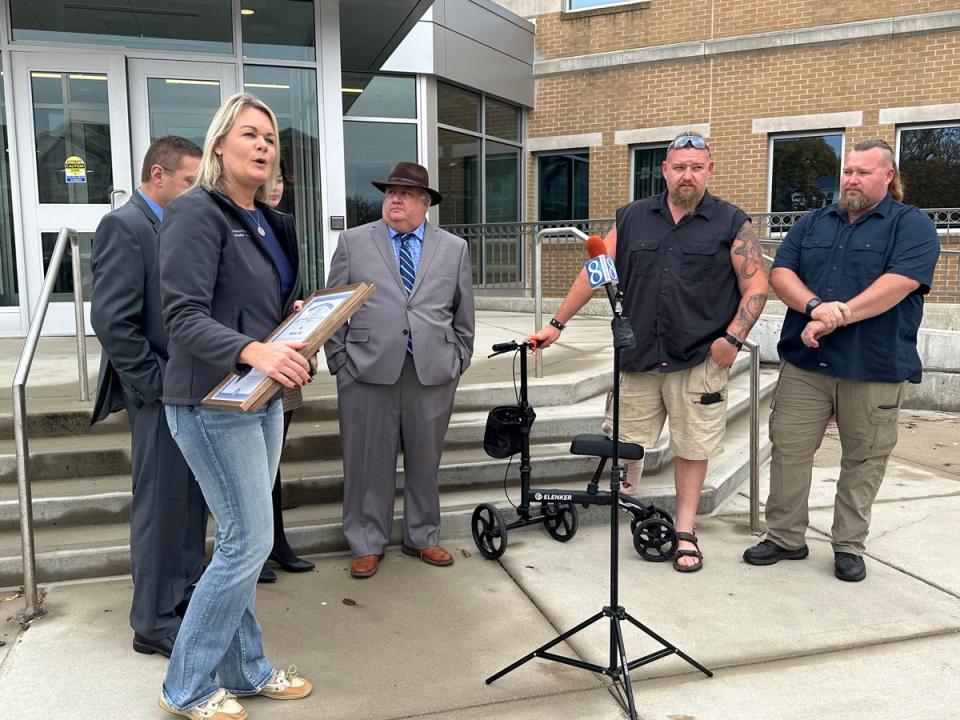 Michigan state rep Rachelle Smit, left, presents a plaque with Michigan state’s coat of arms to Michael and William Null on Friday 27 October (SUPPLIED)