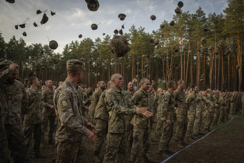 FILE.- Newly recruited soldiers shout slogans as they celebrate the end of their training at a military base close to Kyiv, Ukraine, Monday, Sept. 25, 2023. Ukraine has lowered the military conscription age from 27 to 25 in an effort to replenish its depleted ranks after more than two years of war following Russia's full-scale invasion. The new law came into force Wednesday April 3, 2024, a day after Ukraine President Volodymyr Zelenskyy signed it.(AP Photo/Efrem Lukatsky, File)