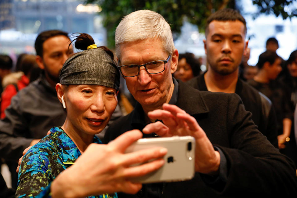 Tim Cook, Chief Executive Officer of Apple Inc., takes a selfie with a customer and her iPhone as he visits the Apple Store in Chicago, Illinois, U.S., March 27, 2018. REUTERS/John Gress