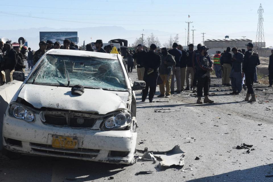 Security officials gather at the site of a suicide bomb attack targeting a police truck in Quetta on 30 November (AFP via Getty Images)