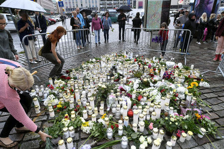 People bring memorial candles and flowers to the Turku Market Square for the victims of Friday's stabbings in Turku, Finland August 19, 2017. Lehtikuva/Vesa Moilanen via REUTERS