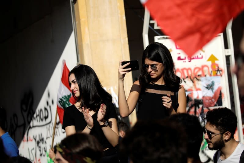 A woman uses her cellphone at a demonstration organised by students during ongoing anti-government protests in Beirut