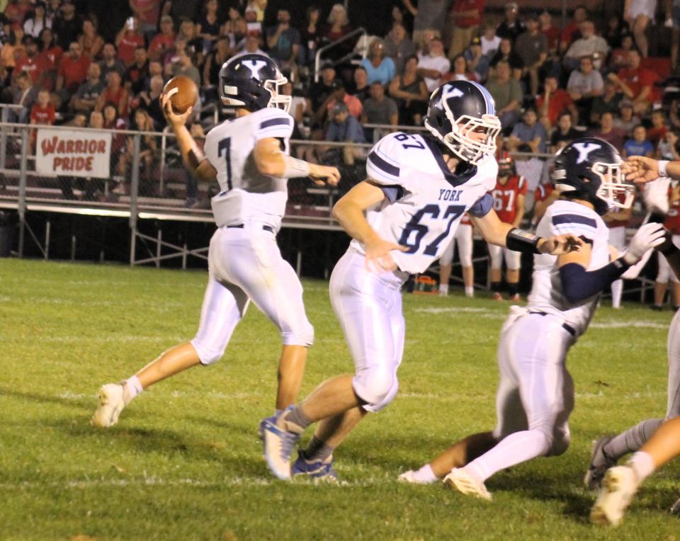 York quarterback Peter Martin (7) gets set to throw a pass as Daniel Rioux (67) helps supply some of the protection during action Saturday night in Wells, Maine.