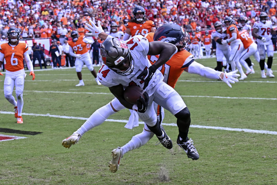 Tampa Bay Buccaneers wide receiver Chris Godwin makes a reception in front of Denver Broncos cornerback Riley Moss for a touchdown during the first half of an NFL football game, in Tampa, Fla. on Sunday, Sept. 22, 2024. (AP Photo/Jason Behnken)