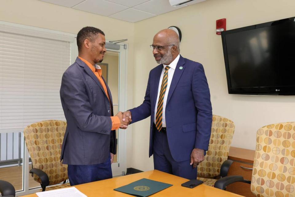 Gregory Gerami (left), president and CEO of Batterson Farms Corp, shakes hands with Florida A&M University President Larry Robinson. Gerami recently announced a $237 million donation to FAMU, the largest ever for a historically Black college or university. But many are skeptical after a similar donation he pledged to Coastal Carolina University in 2020 collapsed. Ernest Nelfrard/Courtesy Florida A&M University