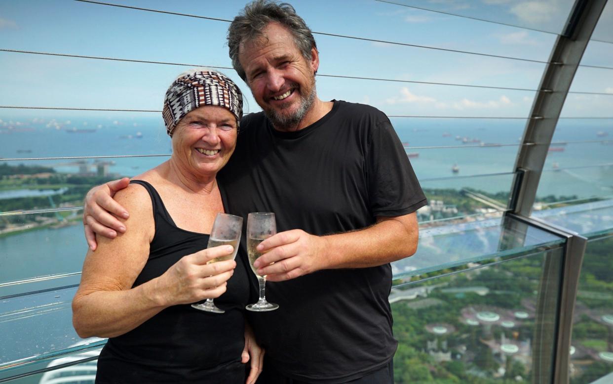 Elaine and Tony Teasdale toast their victory after arriving in Singapore last year - BBC