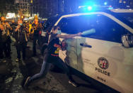 A demonstrator attacks a police car during a protest over the death of George Floyd in downtown Los Angeles, Friday, May 29, 2020. Floyd died in the custody of the Minneapolis police on Memorial Day. (AP Photo/Ringo H.W. Chiu)