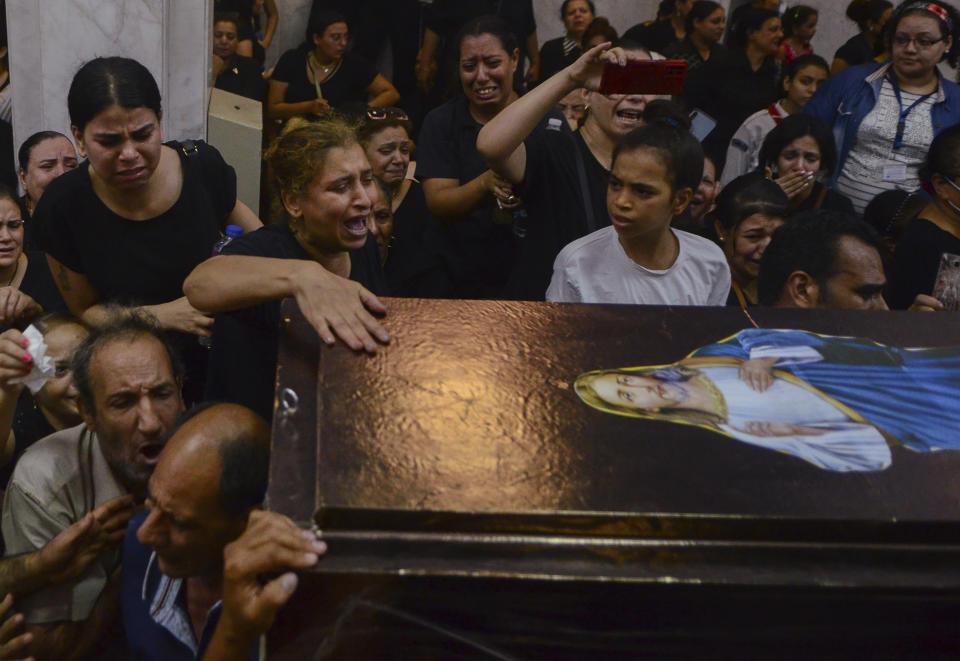 FILE - Mourners attend a service for victims of a fire in a crowded church that killed dozens, at the Blessed Virgin Mary Church in Warraq, greater Cairo, Sunday, Aug. 14, 2022. The fire at the Martyr Abu Sefein Church in the neighborhood of Imbaba, one of Egypt’s most densely populated, left many families devastated, striking a Christian community that is one of the world’s oldest, but is also no stranger to sadness. A minority in Egypt, Coptic Orthodox Christians have faced deadly attacks by Islamist extremists, restrictions on church building and outbursts of sectarian-motivated violence in recent decades. (AP Photo/Tarek Wajeh, File)