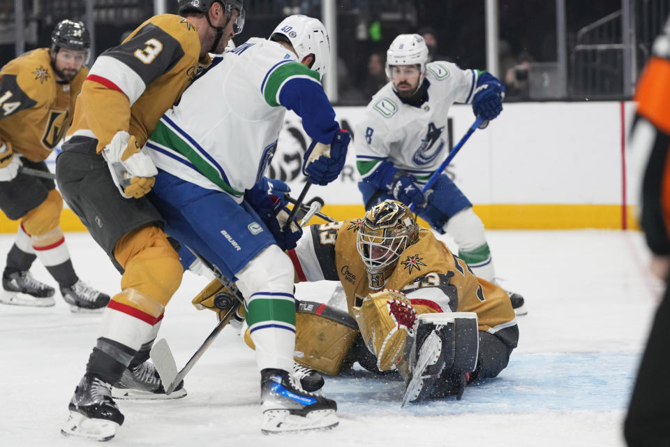 Vegas Golden Knights goaltender Adin Hill (33) makes a save against Vancouver Canucks center Elias Pettersson (40) during the first period of an NHL hockey game Thursday, March 7, 2024, in Las Vegas. (AP Photo/Lucas Peltier)