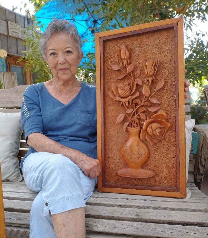 Bellin shows one of her grandfather's intricate wood carvings he created with an exacto knife while interned