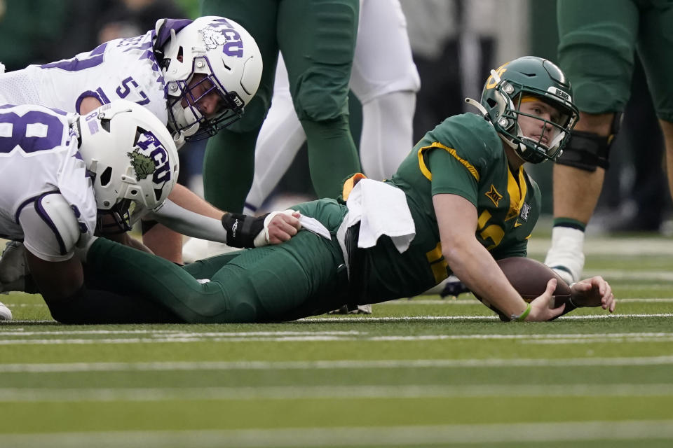 Baylor quarterback Blake Shapen (12) is taken down by TCU linebacker Johnny Hodges (57) and lineman Dylan Horton (98) during the first half of an NCAA college football game in Waco, Texas, Saturday, Nov. 19, 2022. (AP Photo/LM Otero)