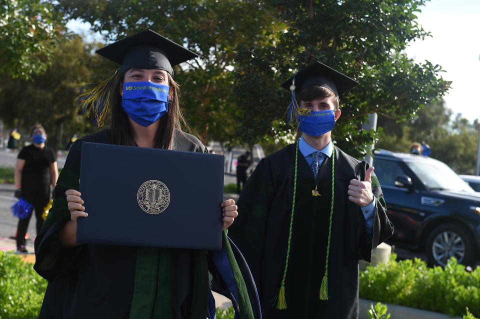 IMAGE DISTRIBUTED FOR UNIVERSITY OF CALIFORNIA, IRVINE - University of California, Irvine medical school graduates show off their degrees. All students, faculty and guests were required to practice social distancing and take public health and safety precautions, during UCI's first "Drive-Thru" commencement ceremony on Saturday, May 30, 2020, in Irvine, Calif. (Jordan Strauss/AP Images for University of California, Irvine)