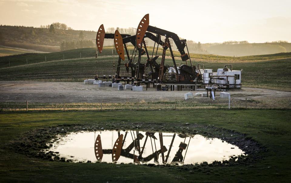 Pumpjacks draw out oil and gas from a well heads as wildfire smoke hangs in the air near Calgary, Alta., on Sunday, May 12, 2024. Canada has the third largest oil reserves in the world and is the world's fourth largest oil producer. THE CANADIAN PRESS/Jeff McIntosh