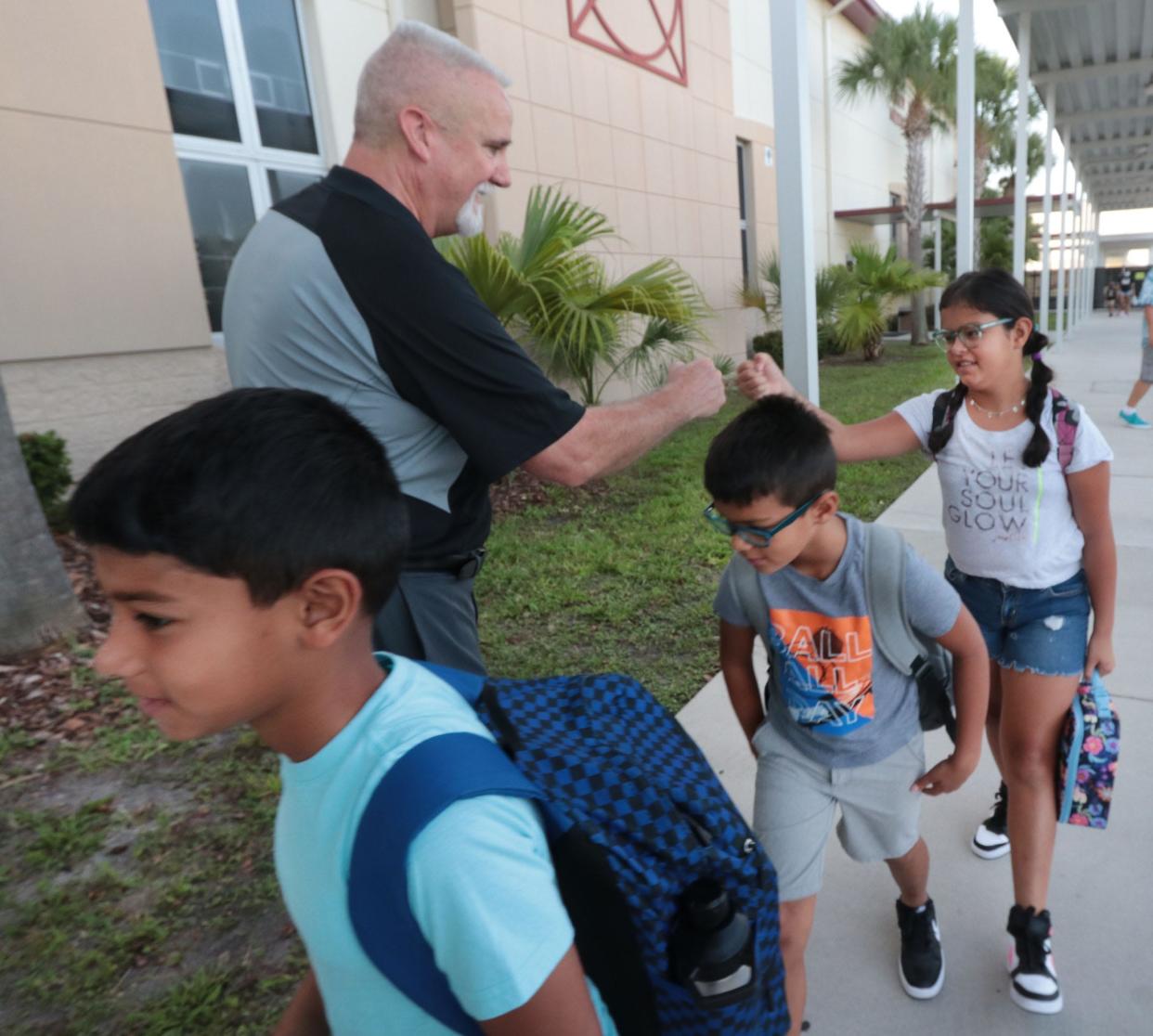 Wadsworth Elementary School Principal Paul Peacock fist bumps a group of students heading to class, Wednesday, Aug. 10, 2022, as Flagler County students return on the first day of school.