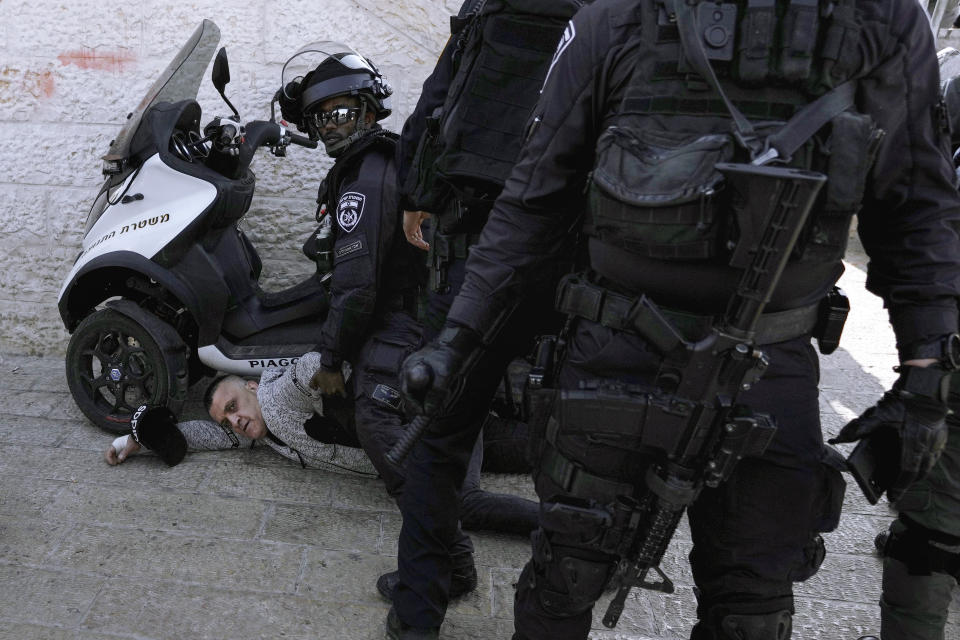 Israeli police officers detain a Palestinian man next to Damascus Gate just outside Jerusalem's Old City, Monday, Feb. 28, 2022. Israeli police arrested 20 people during clashes in east Jerusalem Monday, highlighting tensions during a Muslim holiday celebration. Four officers were injured, the police said. Red Crescent said 33 people were injured and five of them were transferred to a hospital. (AP Photo/Mahmoud Illean)