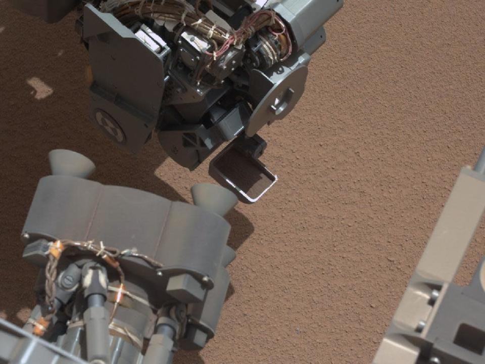 This image from the right Mast Camera (Mastcam) of NASA's Mars rover Curiosity shows a scoop full of sand and dust lifted by the rover's first use of the scoop on its robotic arm. In the foreground, near the bottom of the image, a bright object is visible on the ground. The object might be a piece of rover hardware. (NASA)