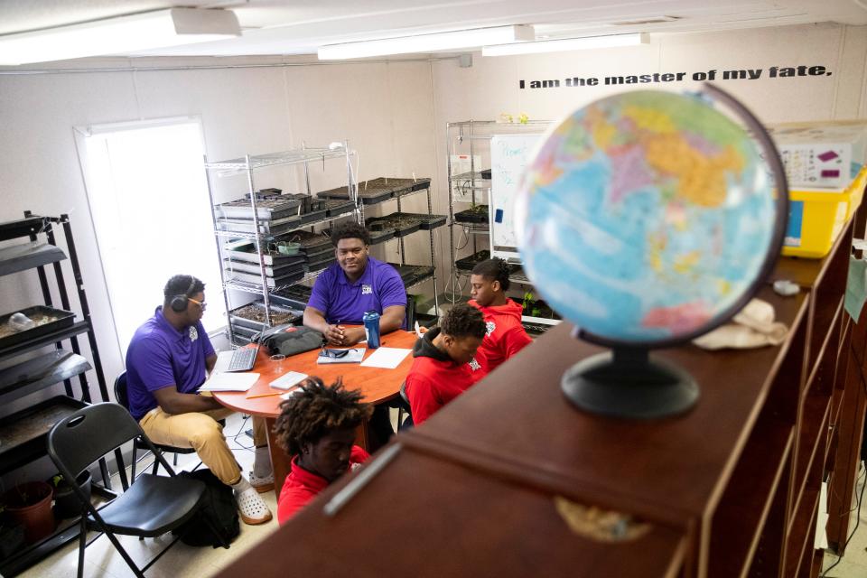 PURE Academy students take part in a class while sitting next to shelves of plants they are growing in Memphis, Tenn., on Tuesday, March 26, 2024.