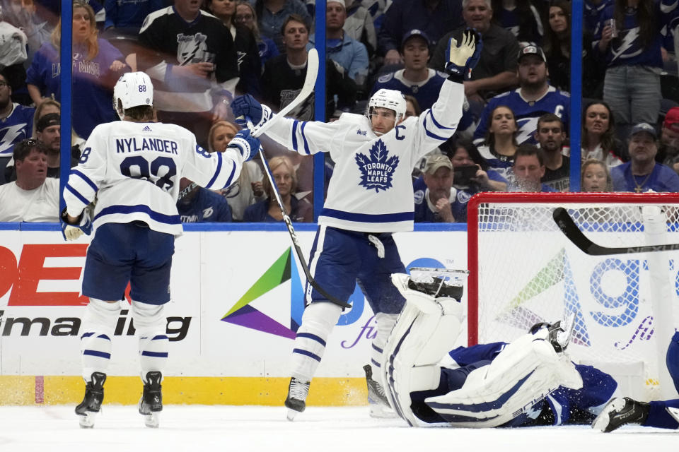 Toronto Maple Leafs center John Tavares (91) celebrates with right wing William Nylander (88) after Tavares scored past Tampa Bay Lightning goaltender Jonas Johansson during overtime in an NHL hockey game Saturday, Oct. 21, 2023, in Tampa, Fla. (AP Photo/Chris O'Meara)