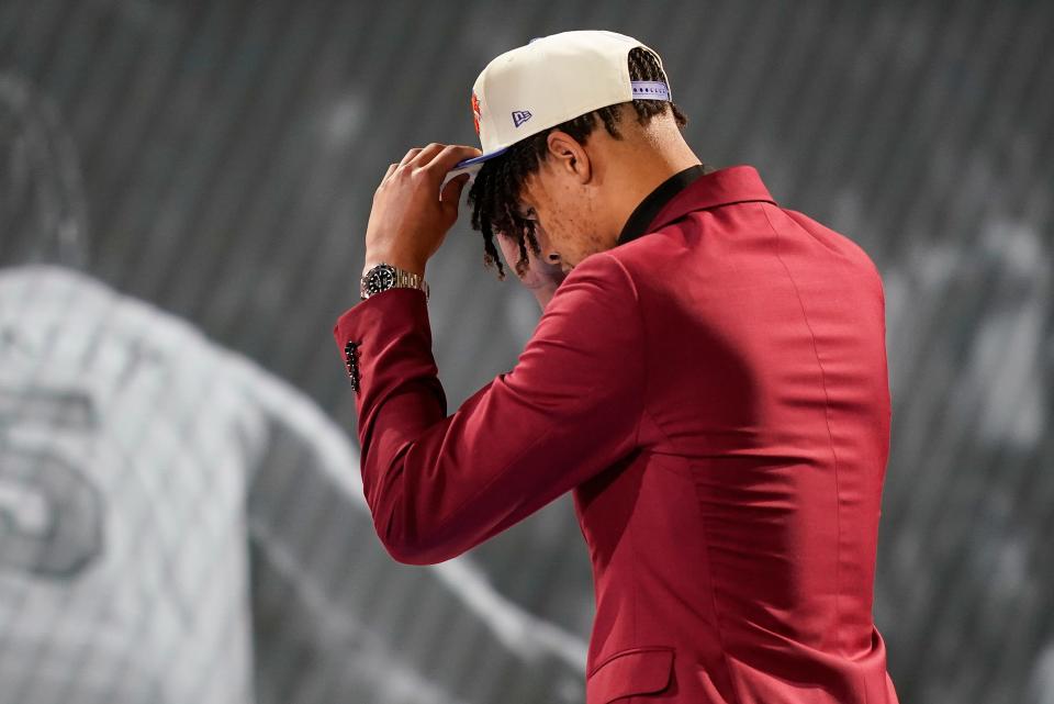 Ousmane Dieng dons a New York Knicks cap after being selected 11th overall by the Knicks in the NBA basketball draft, Thursday, June 23, 2022, in New York. (AP Photo/John Minchillo) ORG XMIT: NYJJ145