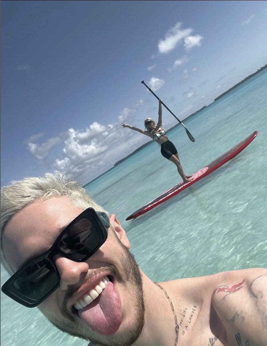 Pete Davidson takes a selfie with Kim Kardashian on a paddle board in the background
