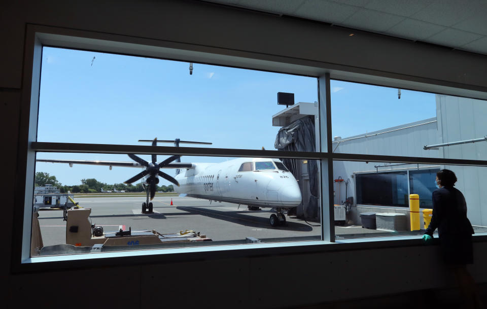 TORONTO, ONT - JULY 4: A Porter Airlines employee waits to board passengers on a flight at Billy Bishop City Airport on July 4, 2022, in Toronto, Ontario, Canada.  (Photo by Gary Hershorn/Getty Images)