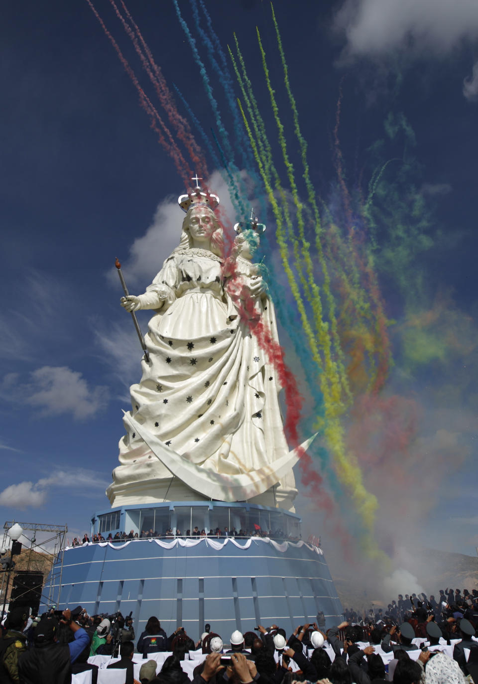 People watch the unveiling of a statue of the Virgin Mary holding a baby Jesus as flares are fired on Santa Barbara hill in the mining city of Oruro, Bolivia, Friday, Feb. 1, 2013. The 45 meter (147 feet) statue of Mary that took four years to build, known in Spanish as "Virgen del Socavón," or the Virgin of the Tunnel, is Oruro's patron, venerated in particular by miners and folkloric Carnival dancers. (AP Photo/Juan Karita)