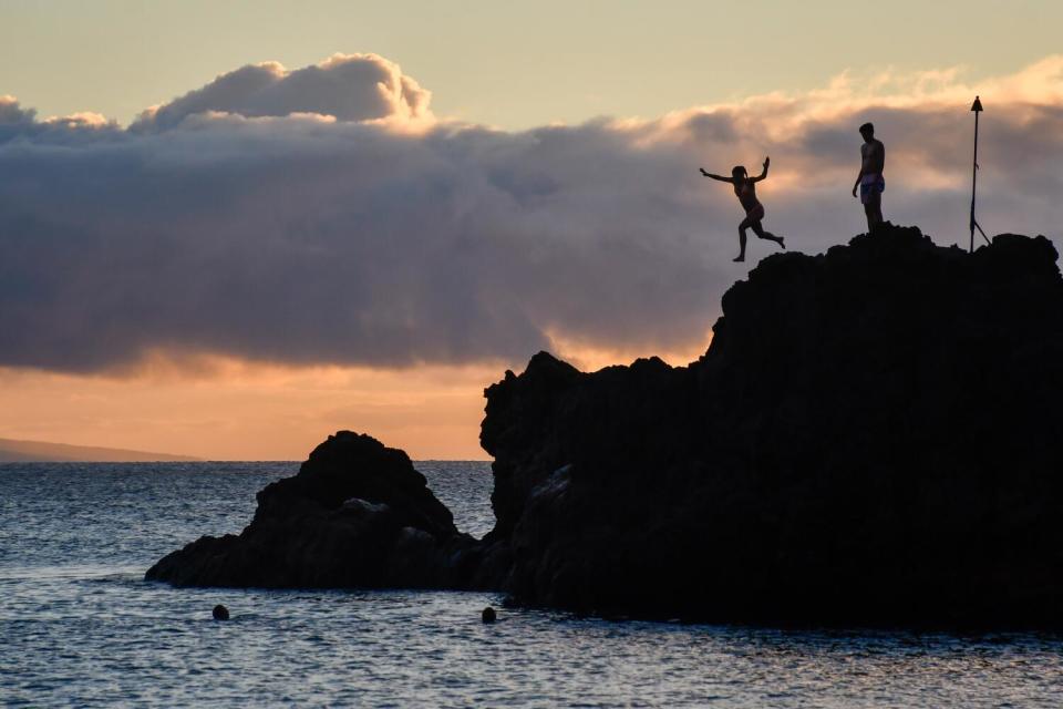 People on Black Rock Beach, Ka'anapali, West Maui, at sunset.