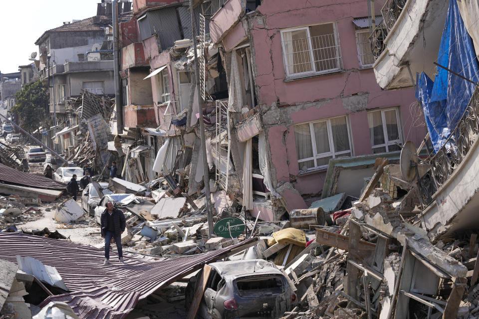 A man walks over debris of collapsed buildings in Hatay, Turkey, Saturday, Feb. 11, 2023. Emergency crews made a series of dramatic rescues in Turkey on Friday and Saturday, pulling several people from the rubble days after a catastrophic 7.8-magnitude earthquake killed thousands in Turkey and Syria. (AP Photo/Hussein Malla)