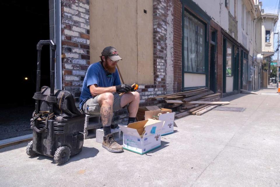 Chris Evans, 37, cuts pipes Tuesday, July 16, 2024 outside where renovations being done on the building on the corner of N. Upper and Short Street. Crews have found at least five layers of flooring in the old building.