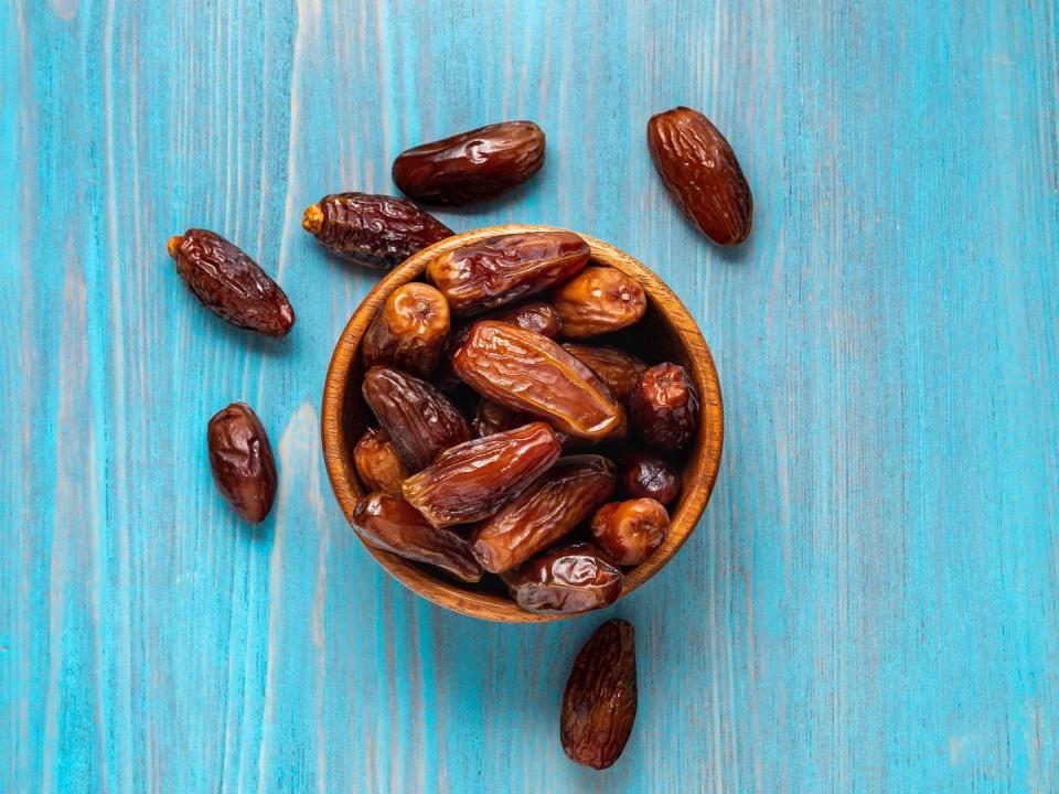 dried dates in wooden bowl