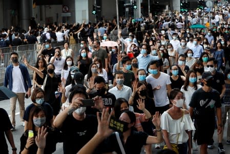 Anti-government office workers wearing masks attend a lunch time protest, after local media reported on an expected ban on face masks under emergency law, at Central, in Hong Kong