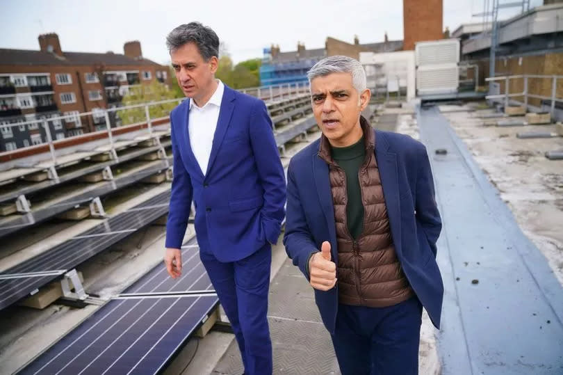 Mayor of London Sadiq Khan (right) and shadow energy secretary Ed Miliband, walk past solar panels installed on the roof of Stoke Newington School in north London