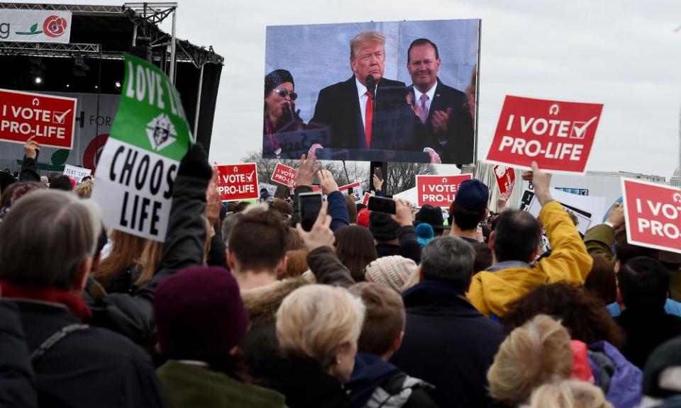 Protesters listen to Donald Trump address the crowd.