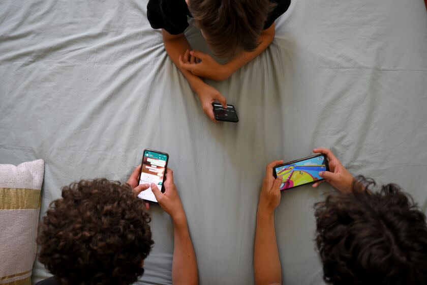 Teenagers hang on to their smartphones in Marseille, southern France, on June 27, 2022. (Photo by Nicolas TUCAT / AFP) (Photo by NICOLAS TUCAT/AFP via Getty Images)