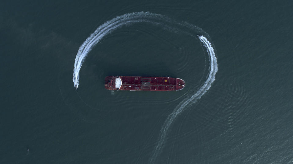 In this Sunday, July 21, 2019 photo, an aerial view shows a speedboat of Iran's Revolutionary Guard moving around the British-flagged oil tanker Stena Impero which was seized in the Strait of Hormuz on Friday by the Guard, in the Iranian port of Bandar Abbas. Global stock markets were subdued Monday while the price of oil climbed as tensions in the Persian Gulf escalated after Iran's seizure of a British oil tanker on Friday. (Morteza Akhoondi/Tasnim News Agency via AP)