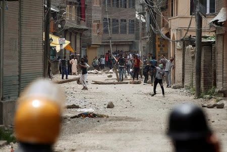 Protesters throw stones towards police during a protest against the killing of Burhan Wani, a separatist militant leader, in Srinagar, July 10, 2016. REUTERS/Danish Ismail