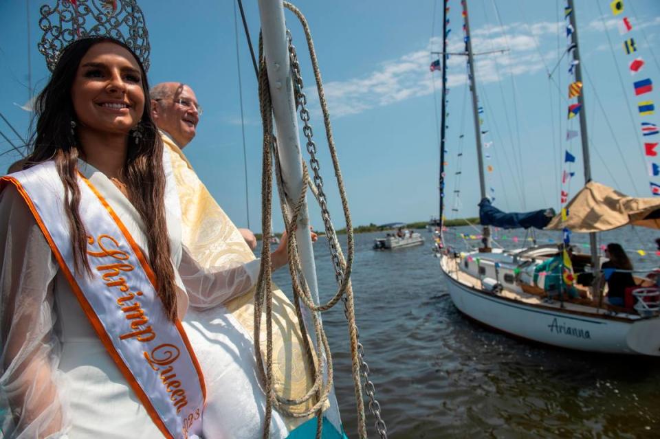 People on a boat wave to Msgr. Dominick Fullam and the Shrimp King and Queen as they receive a blessing during the Blessing of the Fleet in Biloxi on Sunday, May 28, 2023.