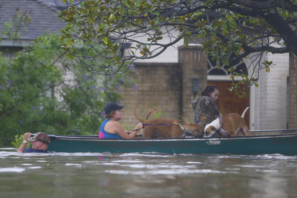FILE - In this Aug. 27, 2017 file photo, a family evacuates their Meyerland home in Houston following Hurricane Harvey. Houston area officials expressed shock and anger on Friday, May 21, 2021, after learning that their communities, which suffered the brunt of damage from Hurricane Harvey, would be getting a fraction of $1 billion that Texas is awarding as part of an initial distribution of federal funding given to the state for flood mitigation. (Mark Mulligan/Houston Chronicle via AP, File)
