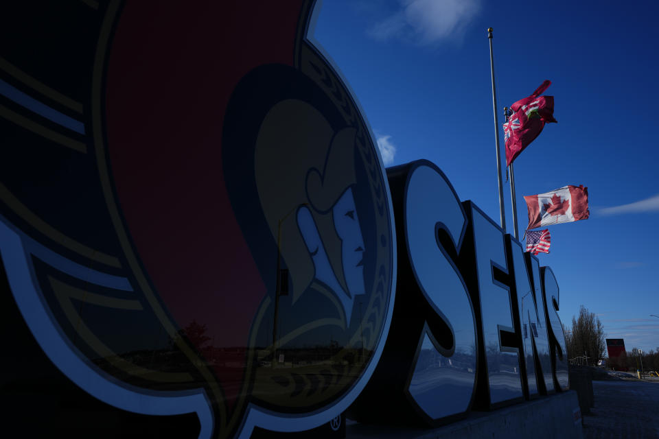 Flags fly at half-mast at the Canadian Tire Centre, the home of the NHL's Ottawa Senators, in Ottawa, Tuesday, March 29, 2022.The Senators announced late Monday night that team owner Eugene Melnyk had died at the age of 62 in Toronto. THE CANADIAN PRESS/Sean Kilpatrick