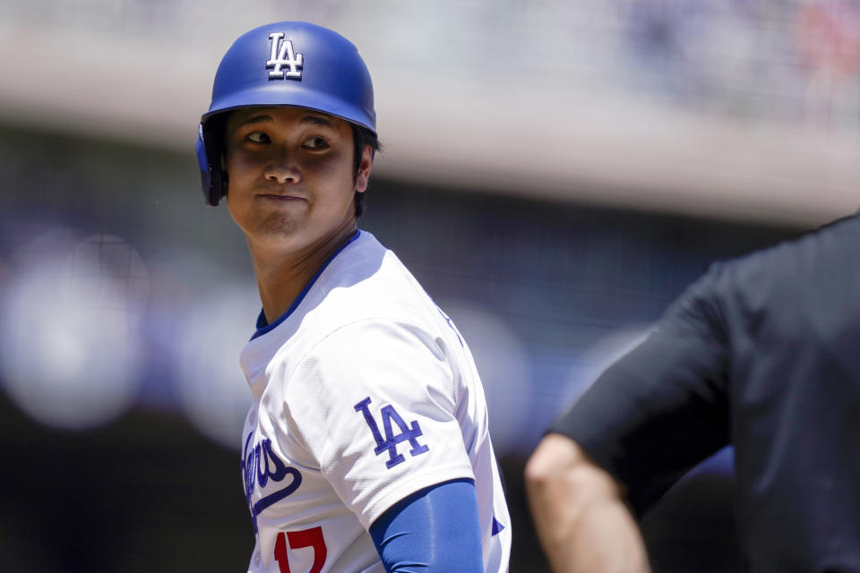 Los Angeles Dodgers designated hitter Shohei Ohtani reacts near an umpire after hitting a single during the first inning of a baseball game against the Washington Nationals, Wednesday, April 17, 2024, in Los Angeles. (AP Photo/Ryan Sun)
