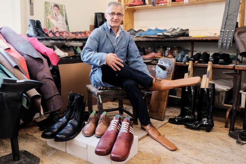 Romanian shoemaker Grigore Lup poses for a portrait while showcasing a pair of his long-nosed leather shoes, amid the outbreak of the coronavirus disease (COVID-19), in Cluj-Napoca